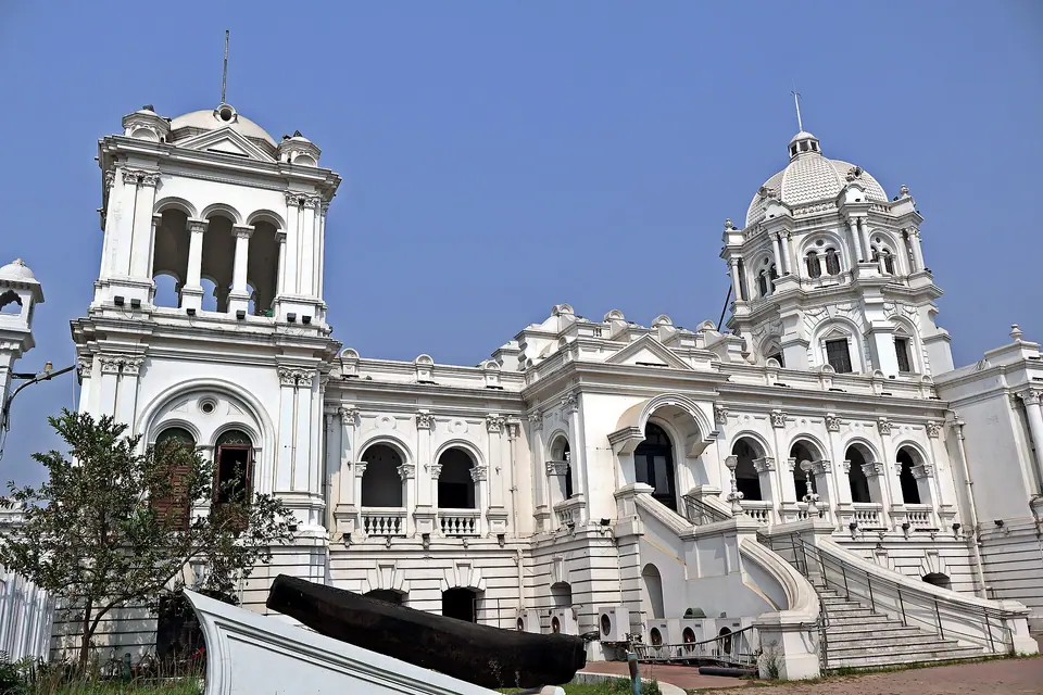 Ornate white facade and domed tower of Ujjayanta Palace against a deep blue sky, Agartala