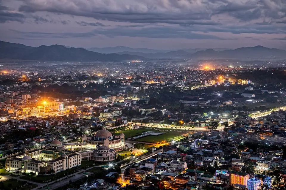 Lights of Imphal spreading across the valley at dusk, with the Manipur hills on the horizon