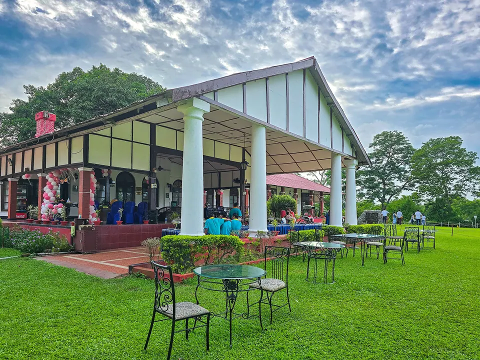 A colonial-style tea planter's bungalow with white columns and a lawn at Sengsua Tea Garden, Jorhat