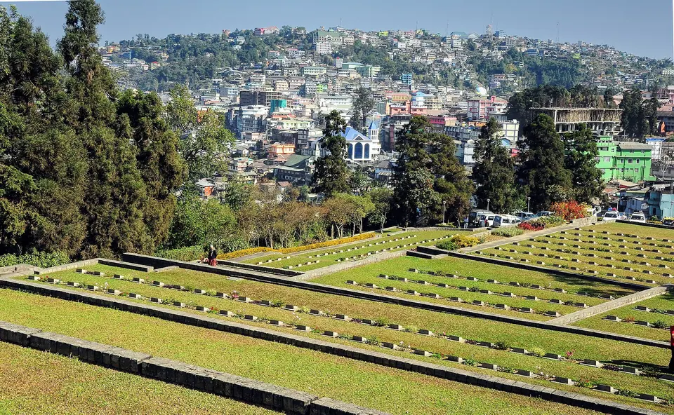 Terraced lawns and headstones of the Kohima War Cemetery on Garrison Hill, with the town behind