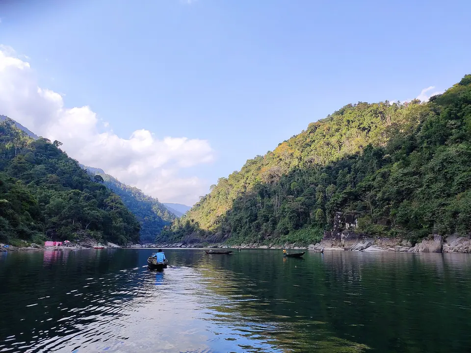 Umngot River flowing still and green between steep forested hills, the stretch that runs past Shnongpdeng