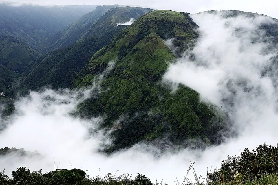 Clouds pouring over a knife-edge green ridge and deep valleys at Laitmawsiang near Sohra, Meghalaya