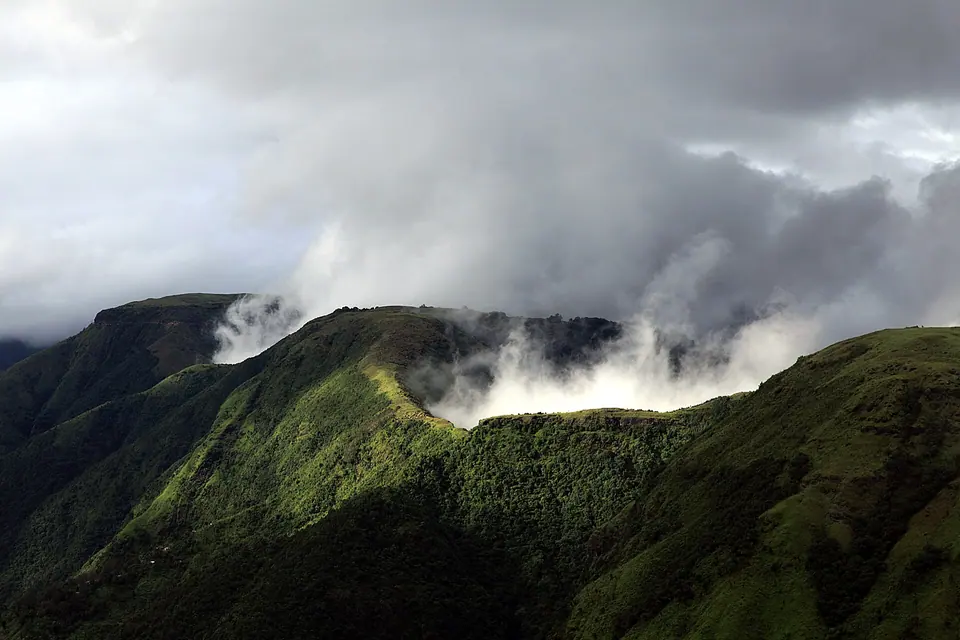 Monsoon clouds spilling over a steep green ridge at Laitmawsiang near Sohra, Meghalaya